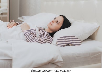 Close-up of exhausted sleepy girl looking tired as lying in bed on pillow, woman with insomnia problems have no sleep at night
