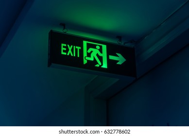 Close-up Exit neon or led sign in corridor point way out of resident apartment building in Hanoi, Vietnam. Lighted wall mounted shining signboard show escape of emergency, urgency, firer. Vintage tone