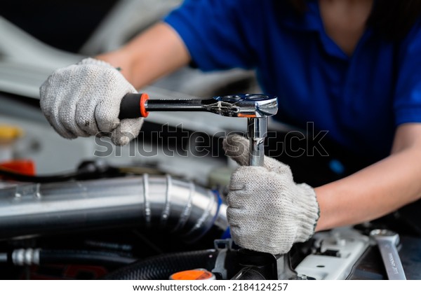Close-up of an expert mechanic working on a\
vehicle in a car service. Engine. Motor repair. Auto mechanic. Auto\
mechanic.