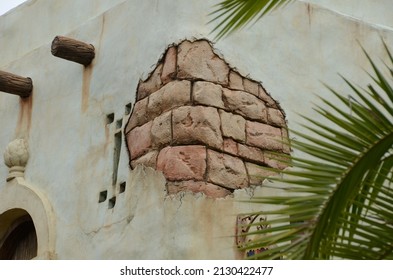 A closeup of exposed bricks that is cracked and chipped on an old wall of a building