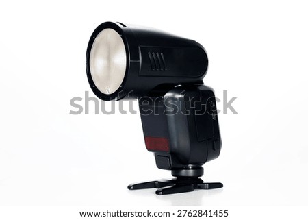 Close-up of an external camera flash used for professional photography, featuring a portable hot shoe lighting accessory designed for studio work, events, portraits, and controlled illumination in various shooting conditions.