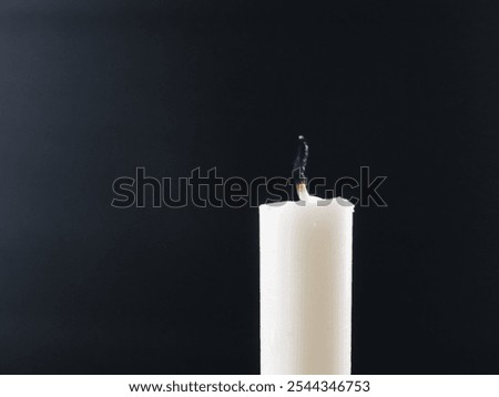 Close-up of extinguished candle, dark background