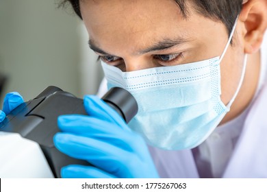 Close-up Eyes Asian Male Researcher Scientist Medical Doctor Wearing Surgical Mask Looking Through Microscope