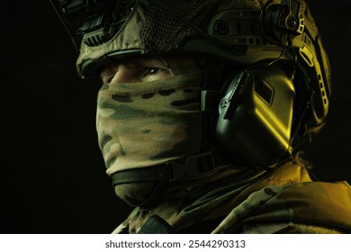 A close-up of a soldier’s eyes, partially covered by a camouflage tactical mask and surrounded by advanced night vision and communication equipment.  - Powered by Shutterstock