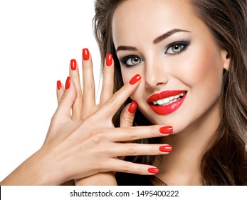 Closeup face of  beautiful smiling woman with red nails and lips isolated on white