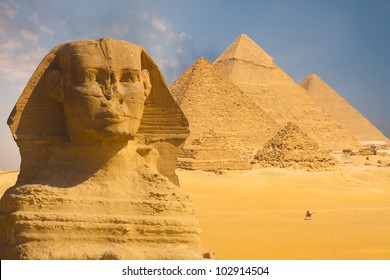 A closeup of the face of the Great Sphinx with a set of pyramids in the background on a beautiful clear blue sky day in Giza, Cairo, Egypt. Horizontal copy space