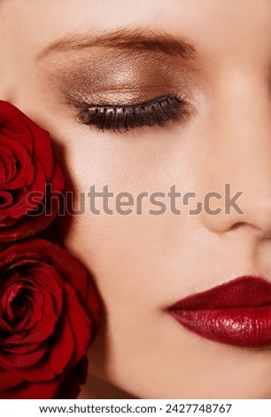 Closeup of face, makeup and beauty with roses, red lipstick and gold eyeshadow with lashes for cosmetics. Shimmer, shine and bold aesthetic, romantic flowers and cropped with skin and cosmetology