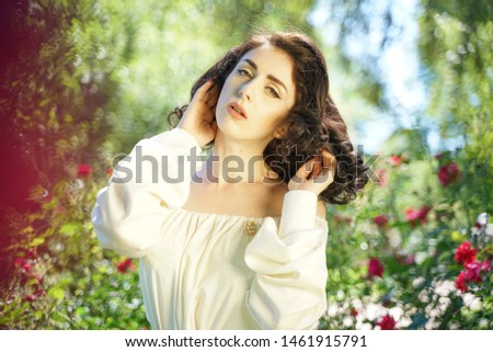 Closeup face of mature woman enjoying the sun at the city park. Beautiful lady relaxing near the green grass and trees.