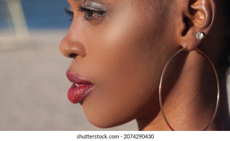 Close-up face portrait of a black girl in profile with large round earrings. Ukraine, Dnipro. September 17, 2018