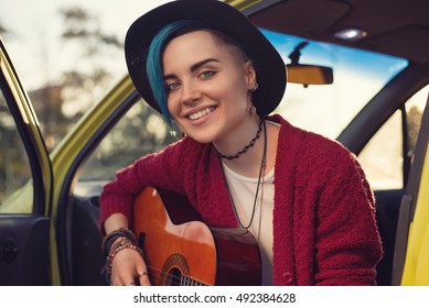 Closeup Face Portrait Of Folk Singer With Guitar In Car Outdoors