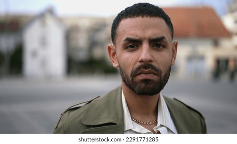 Closeup face of a serious Middle Eastern man looking at camera standing in urban environment - Shutterstock ID 2291771285