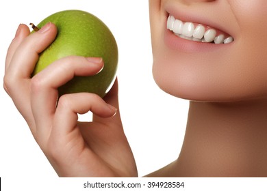 Closeup of the face of a woman eating a green apple, isolated against white background. Beautiful face of young adult woman with clean fresh skin