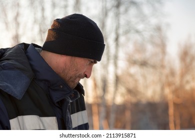 Close-up of the face of a worker in a blue jacket at the workplace