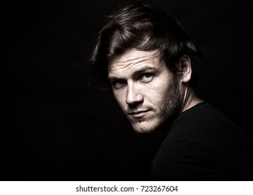 Close-up face of young bearded man on dark background modern and dramatic photo