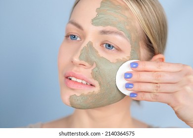 Close-up Of The Face Of A Young Caucasian Blonde Woman. Green Beauty Mask Made Of Clay On The Face. Cosmetic Procedure, Rejuvenation And Skin Care.