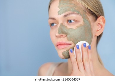 Close-up Of The Face Of A Young Caucasian Blonde Woman. Green Beauty Mask Made Of Clay On The Face. Cosmetic Procedure, Rejuvenation And Skin Care.