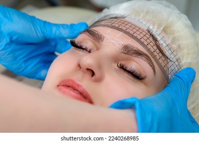 Closeup of Facial Tattoo Markup with Transparent Facial Ruler On Eyebrows of Young Caucasian Woman During a Process of Permanent make up in Salon. Horizontal Image - Shutterstock ID 2240268985