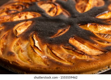 Close-up Failed Apple Pie. Burnt On Top And The Dough Did Not Rise During Baking. Textured Burnt Pie Crust
