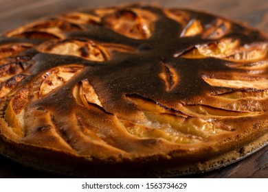 Close-up Failed Apple Pie. Burnt On Top And The Dough Did Not Rise During Baking. Textured Burnt Pie Crust
