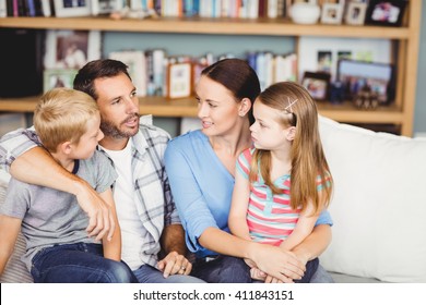 Close-up Of Family Discussing On Sofa In Living Room