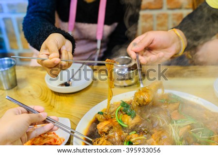 Close-up of a family eating a traditional Korean food, ginseng chicken soup. Korean food is loved by foreign tourists. Ginseng chicken soup a Korean dish, must be eaten when it is hot. Braised Chicken