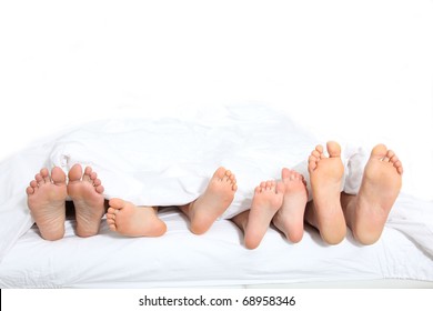 Closeup Of Family Feet In Bed