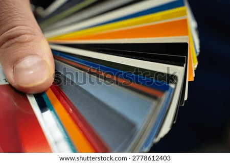 Close-up of a fan deck with multicolored sample strips, showing a range of color options for material or design selection.