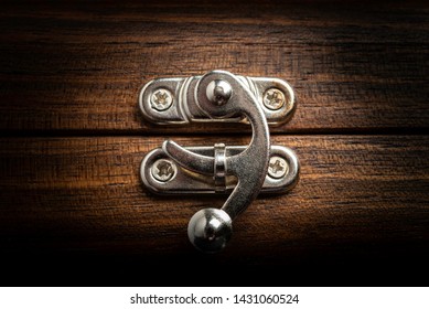 A Close-up Of A Fancy Silver-colored Metal Sliding Clasp Lock On A Wood Box In Horizontal Image Format.