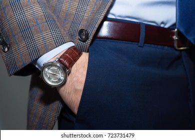 Closeup Fashion Image Of Luxury Watch On Wrist Of Man.body Detail Of A Business Man.Man's Hand In Checkered Jacket,in Dark Blue Pants Pocket Closeup.Casual Outfit. Tonal In A Business Suit Close Up