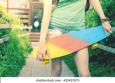 Close-up fashion skateboarder girl with skateboard outdoor near sport shop. Skatebord at city, street. Cool, Fun Tenager. Skateboarding at Summer - Powered by Shutterstock