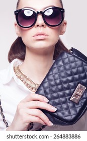 Closeup Of Fashionable Model In Sunglasses And Little Black Handbag