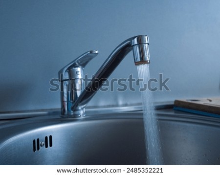 Close-up of faucet and jet of water pouring into the sink. Observe the steady flow from the faucet, showcasing the clarity and force of water. The faucet provides a consistent and powerful stream.