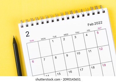 Close-up February 2022 desk calendar on yellow background.