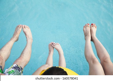 Close-up Of Feet Of Family In The Pool