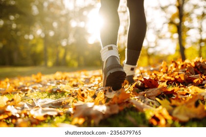 Close-up of feet in hiking boots in a clearing among fallen leaves in a sunny autumn park. Lifestyle concept, outdoor walk. - Powered by Shutterstock