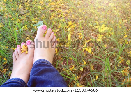 Closeup feet of a lady relaxing on a grass at the park.