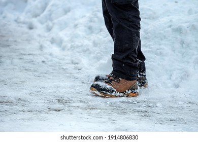 Close-up Of Feet Of Man With Brown Leather Boots In The Snow On Side View