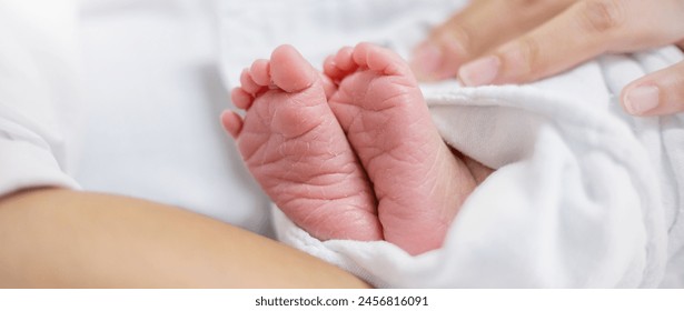 Closeup feet of newborn African black baby infant isolated on white hospital bed sheet. Healthcare and medical love lifestyle father or mother’s day, nursery day care background concept banner - Powered by Shutterstock