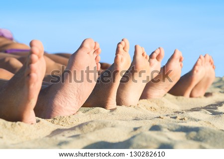 Closeup of feet row lying in line at summer beach
