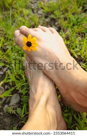 Close-up of feet and toes with flower. 
