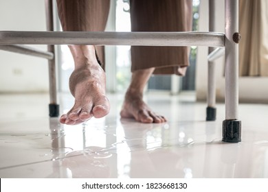 Closeup Of The Feet,Asian Elderly Person Use A Walker To Help Her Walk,water Spilled On The Ground,careful Of Slippage,senior Woman Is Stepping On The Wet Floor,danger,accident,damage Of Slip And Fall