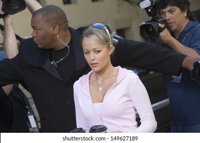 Closeup Of A Female Celebrity And Bodyguard Surrounded By Paparazzi