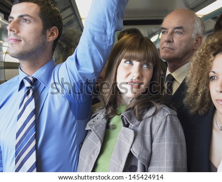 Closeup of a female commuter standing by man's wet armpit in a crowded train