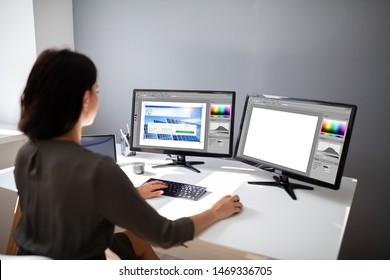 Close-up Of A Female Designer Working On Multiple Monitors At Workplace