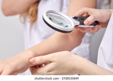 Close-up of female doctor checking patient using magnifying glass at hospital