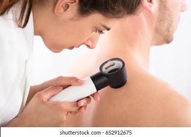 Close-up Of A Female Doctor Examining Skin Of Patient With Dermatoscope