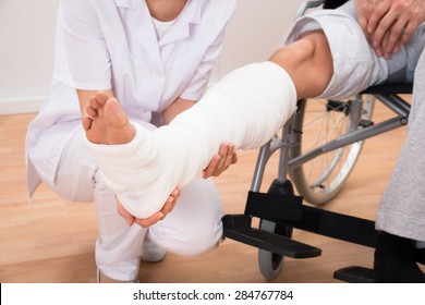 Close-up Of A Female Doctor Holding Disabled Patient's Leg