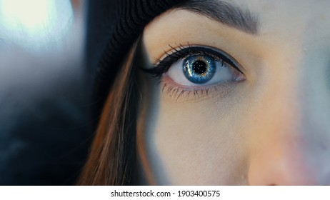 Close-up Of Female Eye Opening With Beautiful Blue Iris. Reflection Of Christmas Lights And Garlands In The Woman Eye