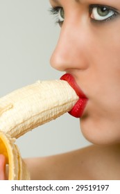 closeup of female face biting a banana