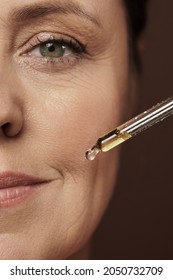 Closeup Of Female Face And Dropper With Rejuvenating Serum